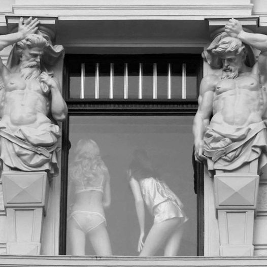 Blague   jeux d'image   2 statues sur les cote de la fenêtre qui regarde  vers l'intérieur avec 2 femmes en petit tenu derrière la fenêtre