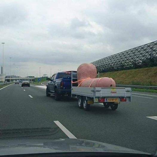 Blague   voiture qui transporte dans sa remorque  qu'il tire une énorme bite